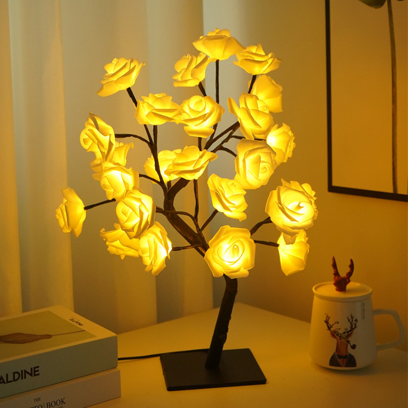 Rose Tree LED Table Lamp on a table next to books and a mug.