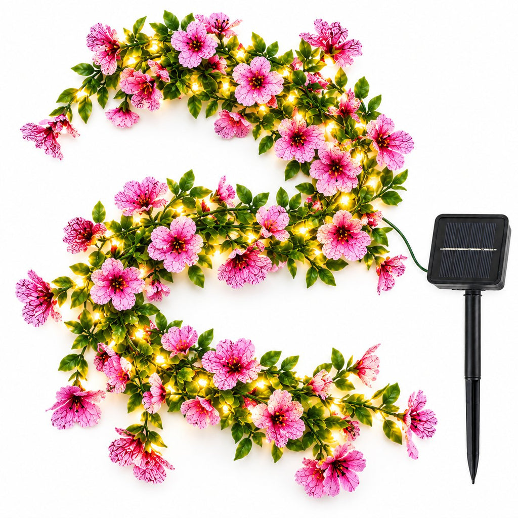 Pink and violet artificial flower fairy light vine arranged in an S shape with black solar panel